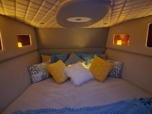 uma cama na parte de trás de um avião com almofadas em A special 24 hours yacht stay em Manama