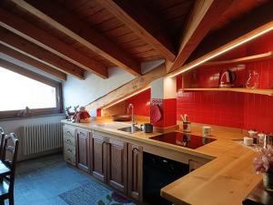 a kitchen with a sink and red tiles at La dzenta méizón in Villeneuve