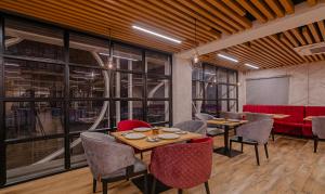 a dining room with tables and chairs and windows at Treebo Tryst D Consulate in Hyderabad