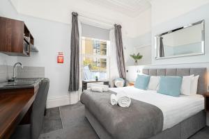 1 dormitorio con 1 cama con lavabo y ventana en Ocean Stays Hotel, Plymouth en Plymouth