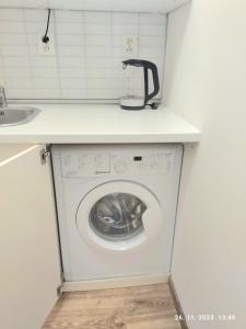 a washing machine under a counter in a kitchen at Minigarsónka in Bratislava