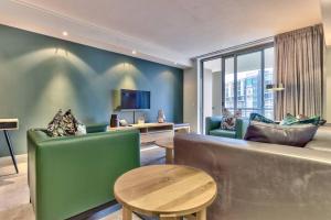 a living room with a couch and a table at Luxury 1 Bedroom apartment in Canal Quays in Cape Town