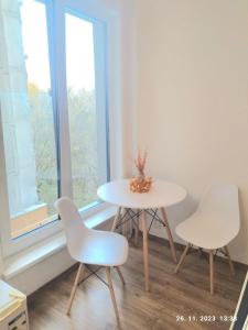1 mesa y 2 sillas en una habitación con ventana en Minigarsónka, en Bratislava