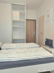 1 dormitorio con 1 cama grande y TV en Minigarsónka, en Bratislava