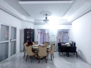 a dining room with a table and chairs at Belle loge de 5 pièces à proximité de l'aéroport in Cotonou