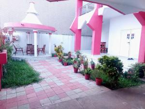 un patio con macetas y un pabellón con mesas y sillas en Belle loge de 5 pièces à proximité de l'aéroport, en Cotonou