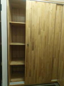 a wooden cabinet with empty shelves in a room at Belle loge de 5 pièces à proximité de l'aéroport in Cotonou