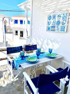 a table with blue and white chairs on a patio at LemonStello Kythnos in Dhriopís