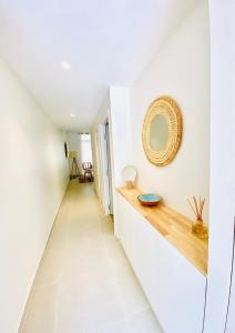 a hallway with white walls and a mirror on the wall at Tahiti Beach apartment in Paea