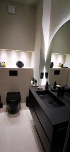 uma casa de banho com um WC preto e um lavatório preto em Quedlinburg Marktplatz-Suites em Quedlinburg