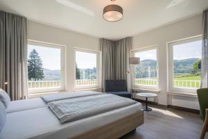 ein Schlafzimmer mit Bett und großen Fenstern in der Unterkunft St. Bonifatius in Winterberg