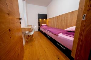 a bedroom with a bed and a desk with a chair at Cirus apartments in Kočevje