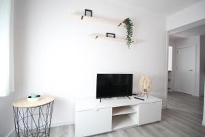 una sala de estar con TV en un armario blanco en Cómodo piso en el Pirineo Aragonés, en Sabiñánigo