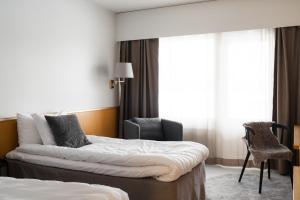 瓦尔凯阿科斯基瓦尔迪卡酒店的一间酒店房间，里面有一张床和一把椅子