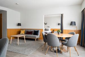 a living room with a table and chairs and a couch at Hotel Waltikka in Valkeakoski