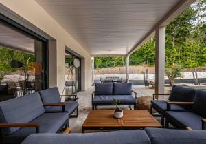 a patio with blue couches and a table at VILLA ***** PISCINE CHAUFFÉE, JACCUZI, PÉTANQUE in Moirax