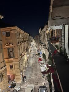 a city street at night with parked cars and buildings at Casa Piemont in Casale Monferrato