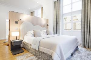 a bedroom with a large bed and a large window at Grand Hôtel Du Palais Royal in Paris