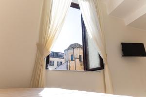 a bedroom with a window with a view of a building at LA MASCHERA DI PULCINELLA in Naples