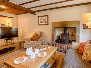 a living room with a fireplace and a table at 2 Bed in Winster PK885 in Winster