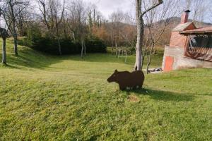 eine Statue einer Kuh, die auf einem Feld steht in der Unterkunft Kuća za odmor Ana in Josipdol