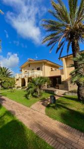 a house with palm trees in front of it at San Michele Apartments&Rooms in Catanzaro