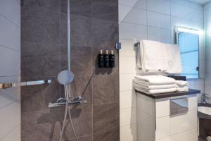 a bathroom with a shower with a glass door at Clarion Collection Hotel Bergmästaren in Falun