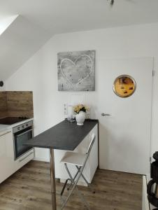 una cocina con una mesa y una pintura al corazón en la pared en Ferienwohnung Astenrefugio, en Winterberg