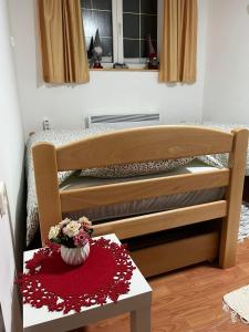 a bedroom with a bed and a table with flowers at Apartman Cogan - 100m from Gondola - Brzece in Kopaonik +7 photos