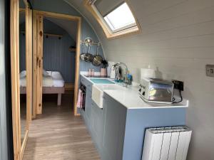 a small kitchen with a sink and a window at Warren Farm Retreat - Pod 1, Pod 2, and The Lodge by SSW in Cardiff