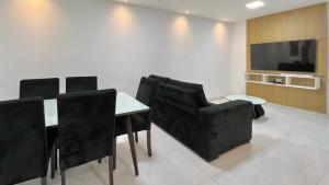 uma sala de conferências com uma mesa e cadeiras e uma televisão em Casa Macao Tibau do Sul em Tibau do Sul