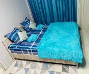 - un lit avec des couvertures et des oreillers bleus dans l'établissement Апартаменты на Бурова, à Öskemen