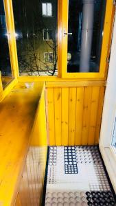 une chambre jaune avec un banc devant une fenêtre dans l'établissement Апартаменты на Бурова, à Öskemen