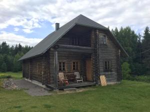 Haanja的住宿－Vällamäe talu puhkemaja，小木屋配有2把椅子和桌子