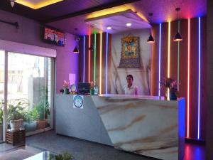 a woman standing behind a counter in a room with purple walls at HOTEL SG HUB TOWER in Margherita