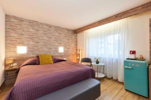 a bedroom with a bed and a brick wall at Hotel Berghof in Baumholder +24 photos