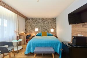 Hotel Berghof في باومهولدر: غرفة نوم مع سرير وبطانية زرقاء