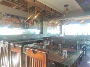 a dining room with a table and wooden chairs at HOTEL SG HUB TOWER in Margherita