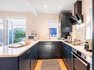 una cucina con armadi blu e una grande finestra di 3 Bed in Swanage 84019 a Swanage
