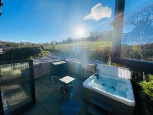 a bathroom with a tub and a view of a field at Pass the Keys The Cosy Romantic and Elegant for 2 with Hot Tub in Hayfield