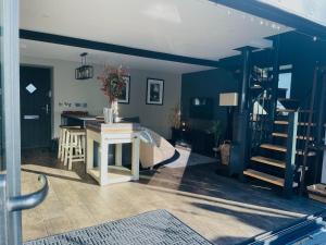 a living room with blue walls and a staircase at Pass the Keys The Cosy Romantic and Elegant for 2 with Hot Tub in Hayfield