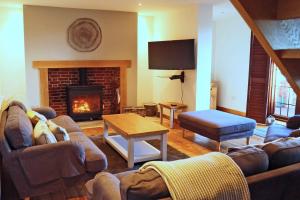 a living room with a couch and a fireplace at Arniss Farmhouse in Fordingbridge