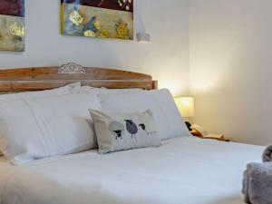 een bed met witte lakens en kussens in een slaapkamer bij 1 Bed in Keswick 86247 in Rosthwaite
