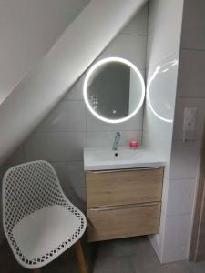 a bathroom with a sink and a mirror and a chair at Maison individuelle, 10 minutes de Colmar 4 chambres - 8 personnes - 2 sdb in Wintzenheim