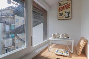 a room with a window and a table with cups on it at I Host Apartment - Carcano 26 in Milan