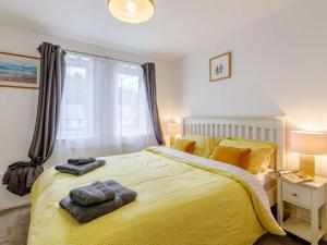 a bedroom with a yellow bed with two towels on it at 2 bed in Caernarfon 86260 in Y Felinheli