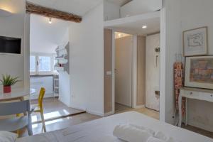 a bedroom with a bed and a table and a kitchen at I Host Apartment - Carcano 26 in Milan