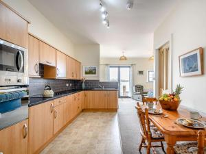 a kitchen with wooden cabinets and a wooden table at 4 bed property in Isle of Bute 85215 in Kilchattan