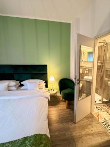 a bedroom with a large bed and a green wall at Trip Inn Boutique Rubens in Essen