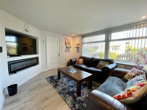 a living room with two couches and a tv at Blakes Beach House Humberston Fitties in Humberston